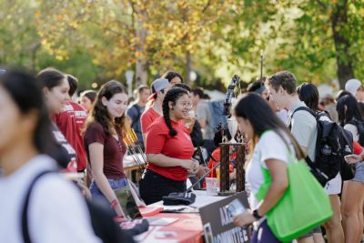 Students staffing a table, with many other student groups around them