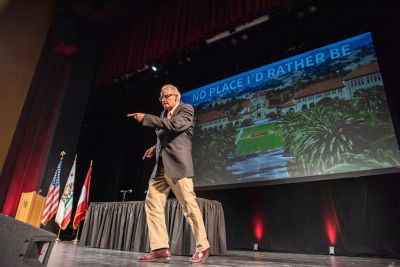 Dean of Admission Rick Shaw dances on stage before speaking to admits and their families at the University Welcome.