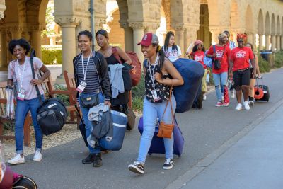 Admits wheel their luggage across campus to their dorm assignments, these students are escorted by their House Hosts to Ujamaa House.