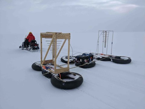 Anna Broome pulling the radar/radiometer she built using ORCA behind a snowmobile near Summit Station in Greenland