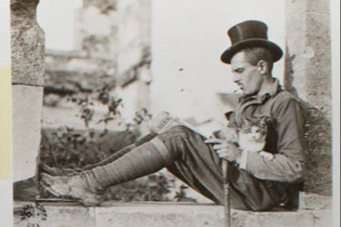 This photo of a cat curled safely in the lap of a man perched on a stone wall is from an album of World War I photographs depicting the activities of the American Expeditionary Forces in France. It is captioned: “This American soldier is not worrying over the dangers and perils of war.”