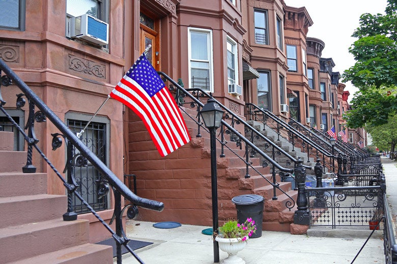 brownstone row houses with American flags waving