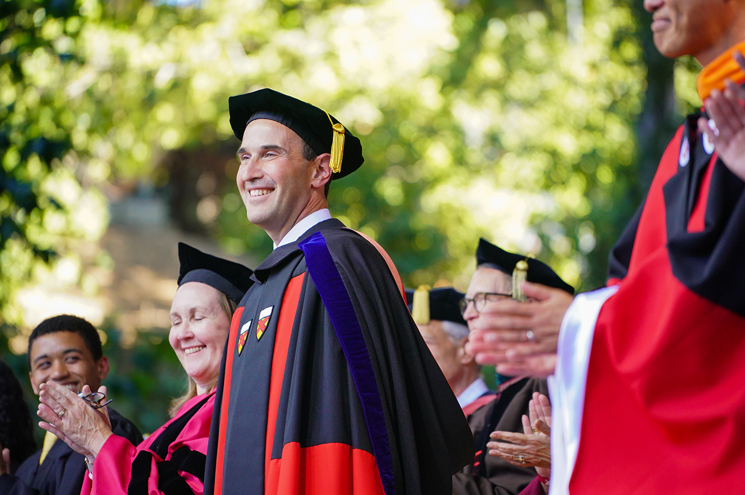 Image of President Levin standing on stage next to the provost and other faculty members.