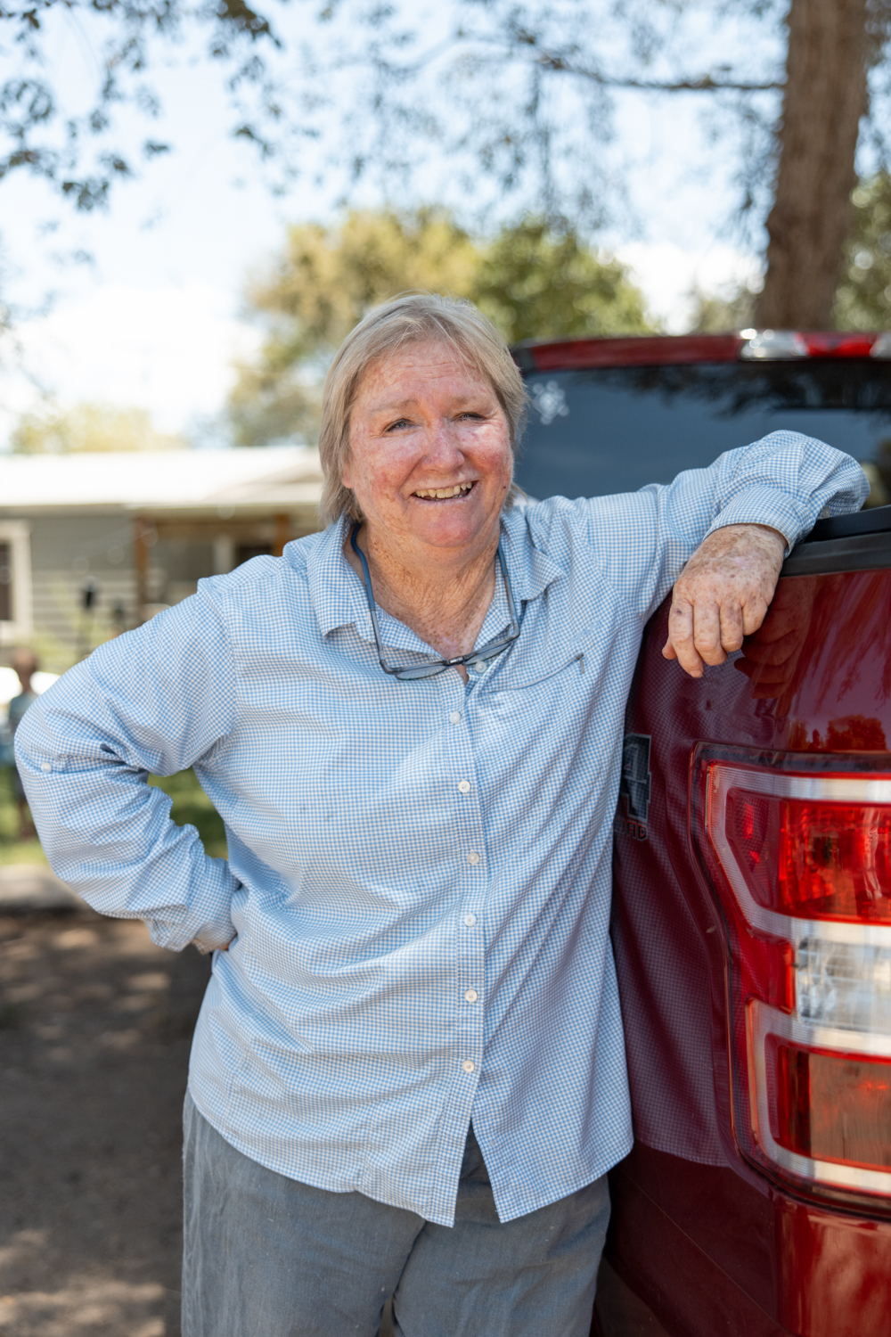 Photo of Tani Tatum leaning against a vehicle and smiling at the camera.