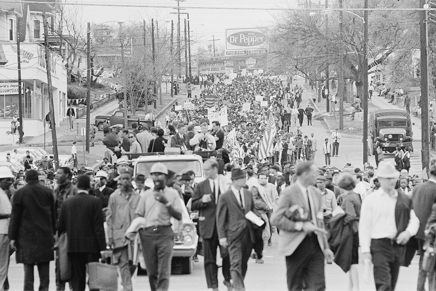 View of demonstrators filling the road far into the distance as they march.