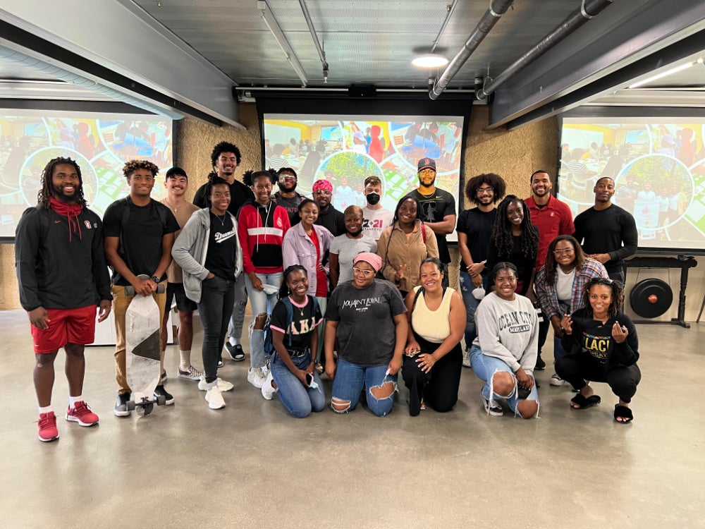 Several dozen students gather in the design lab for a group photo.