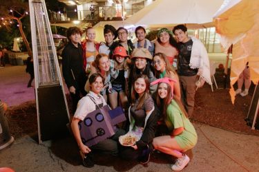 Group photo of a dozen students in costume at Tresidder