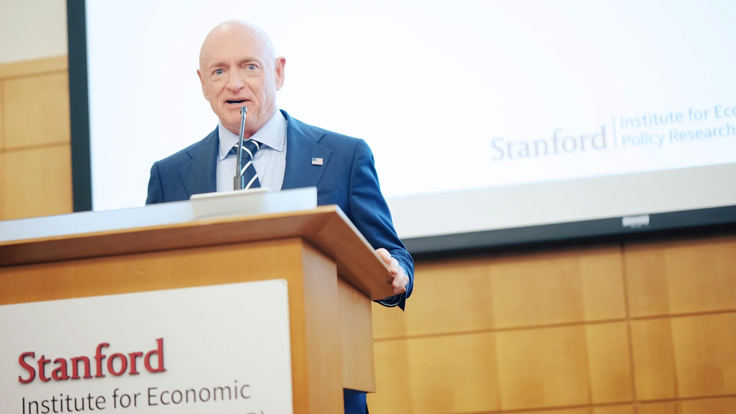 U.S. Senator Mark Kelly stands at podium to delivers keynote address at the SIEPR Policy Forum on 'AI & the Economy' on Nov. 20, 2025. 