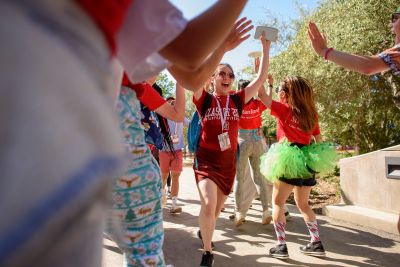 Pro-Fros run a gantlet of welcoming students into Frost Amphitheater.