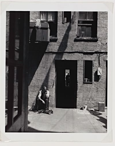 Aaron Siskind’s photography series on St. Joseph’s House, a shelter run by the Catholic Worker Movement in New York, gently draws our attention to small details. Perhaps none are more delightful than the French Bulldog basking in the sun at the feet of his human companion.