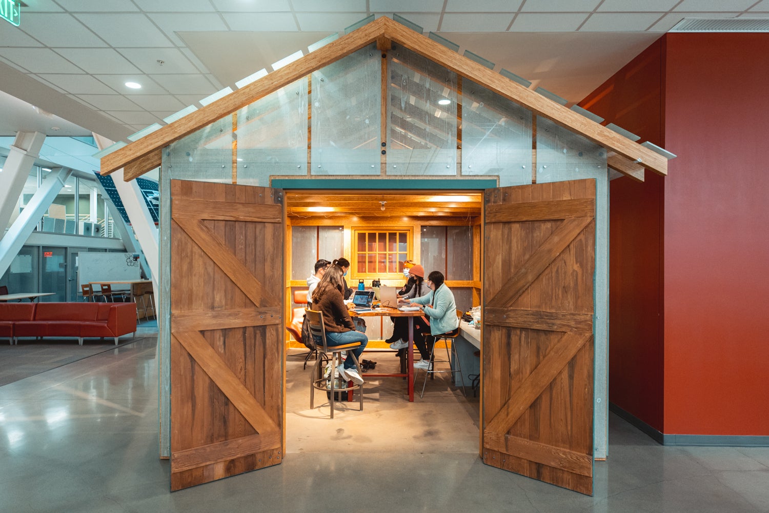 People sitting at a table inside the transparent garage replica