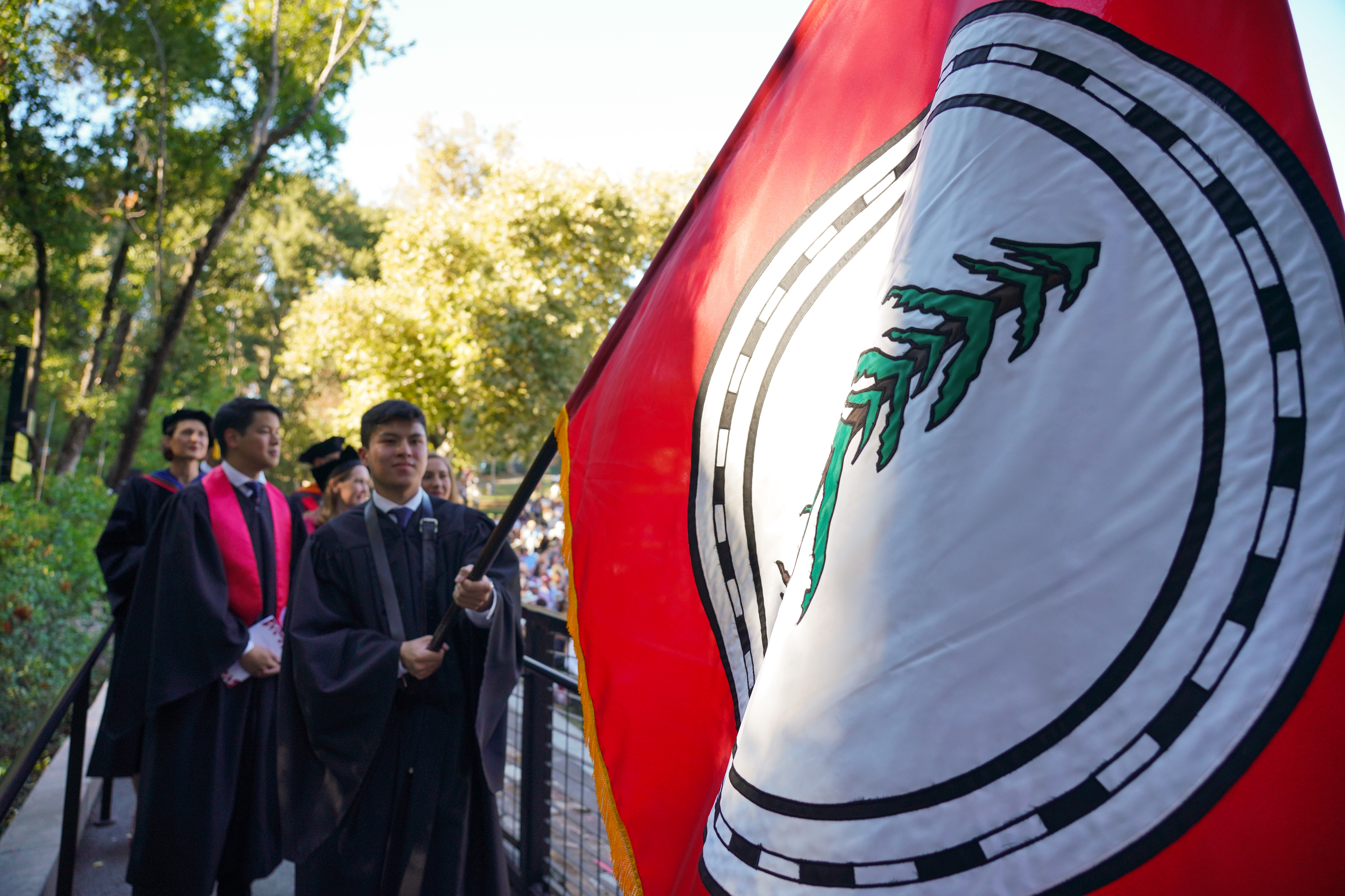 Student flag bearer holding the flag and entering the ceremony