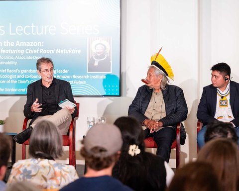 Paulo Moutinho speaks on stage with Chief Raoni and Beptuk Metuktire