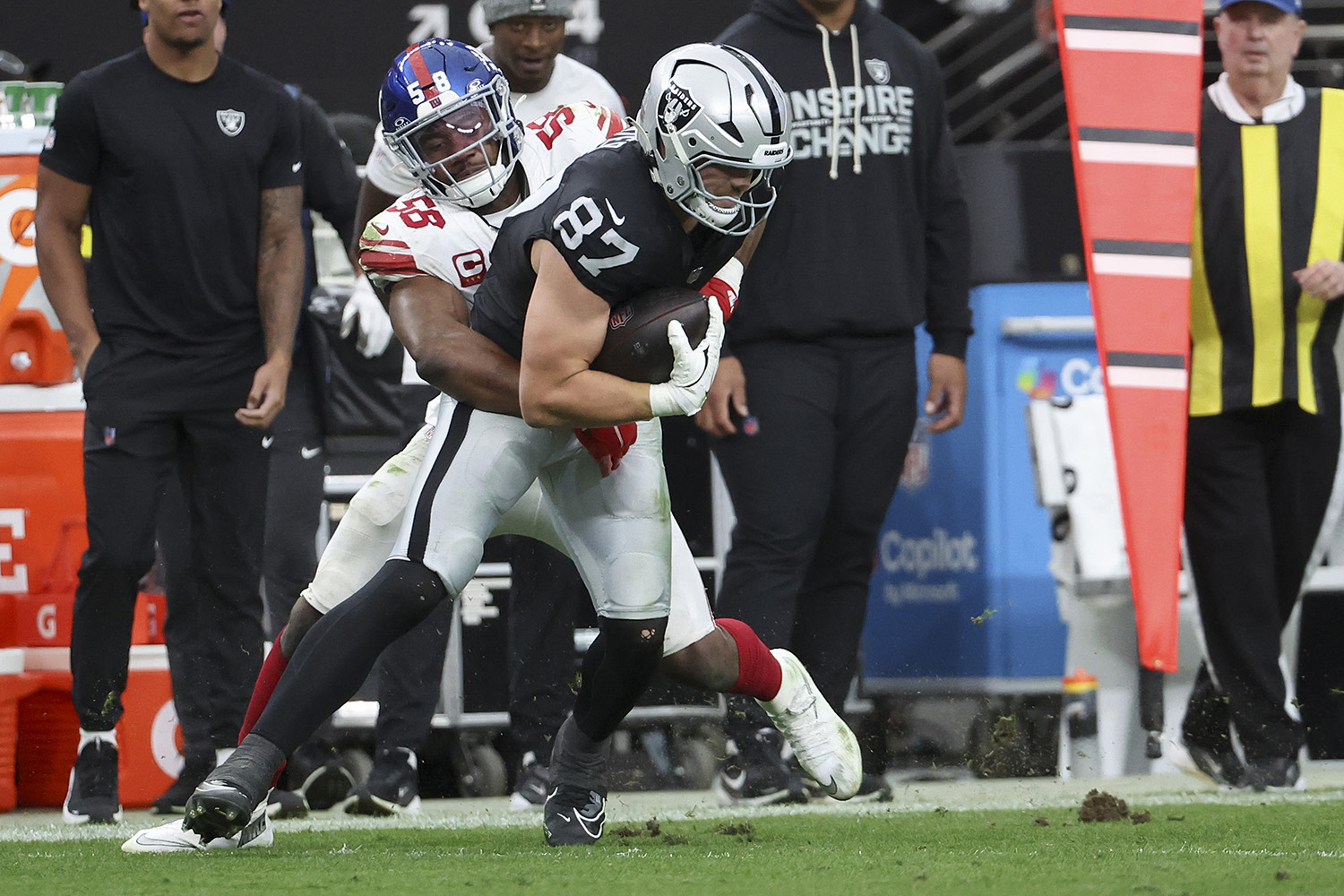 Bobby Okereke #58 of the New York Giants tackles Michael Mayer #87 of the Las Vegas Raiders in the second quarter of a game at Allegiant Stadium on December 28, 2025 in Las Vegas, Nevada.