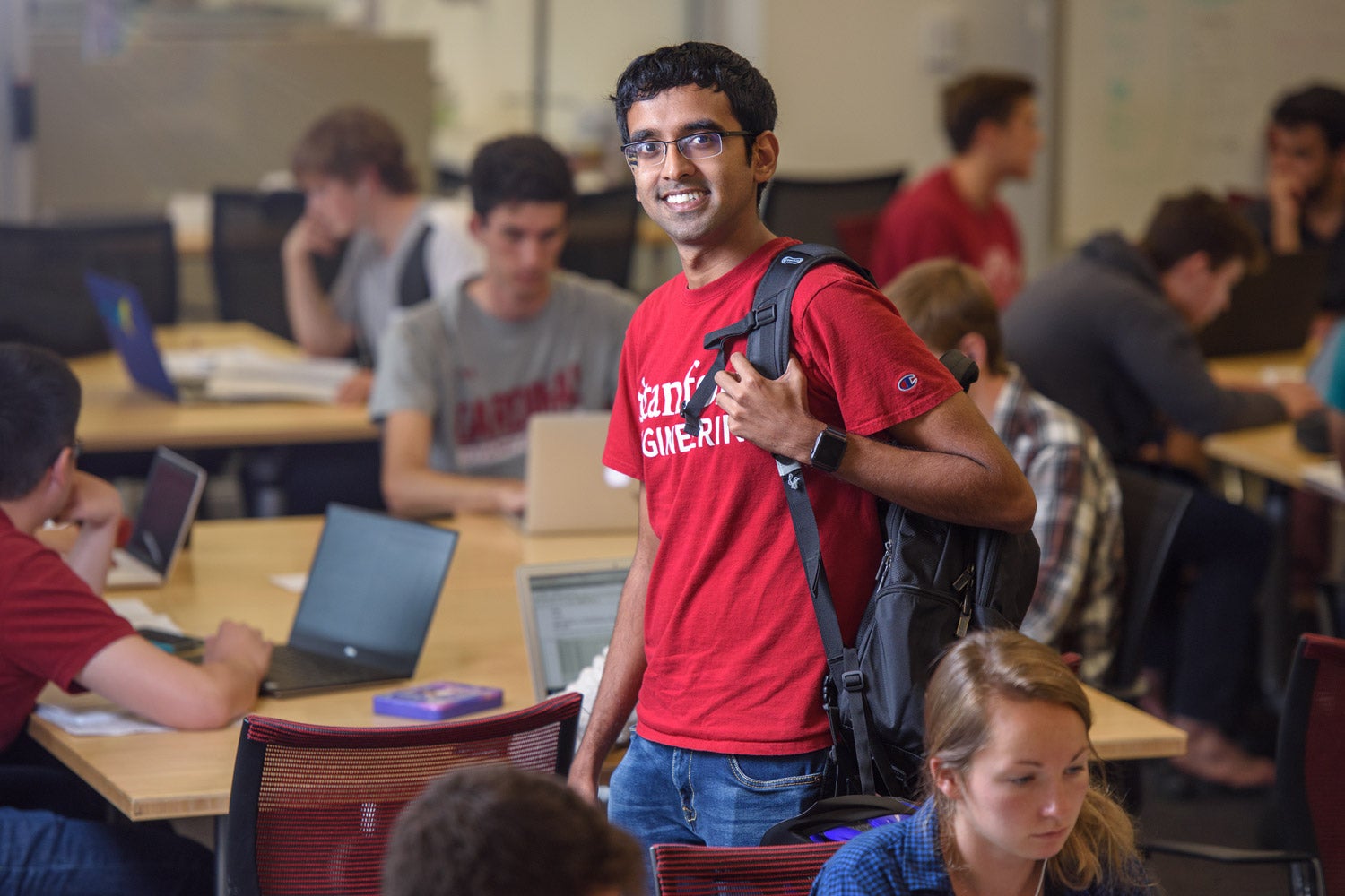 Graduate student Chiraag Sumanth stands among fellow students in the Huang Engineering Center.