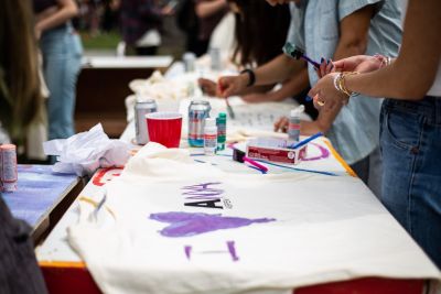 Student decorating a t-shirt with the letter A and Aspen.