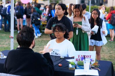 Student seated a table for a tarot card reading.