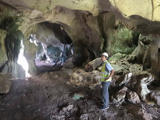 David standing inside a cave wearing a hard hat.