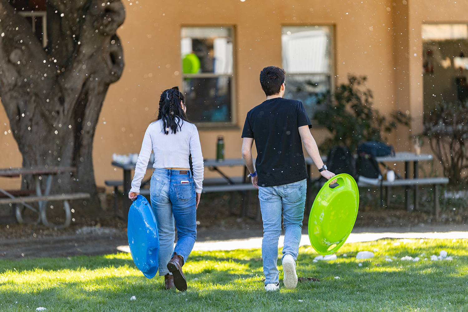 Students walk with plastic sleds.