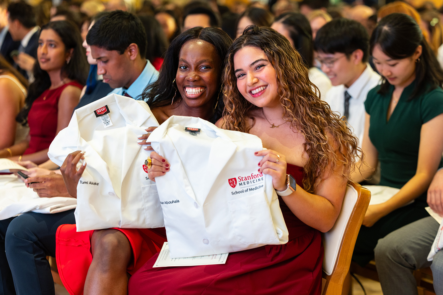 MD students Tumi Akeke and Siwaar Abouhala pose with their white coats.