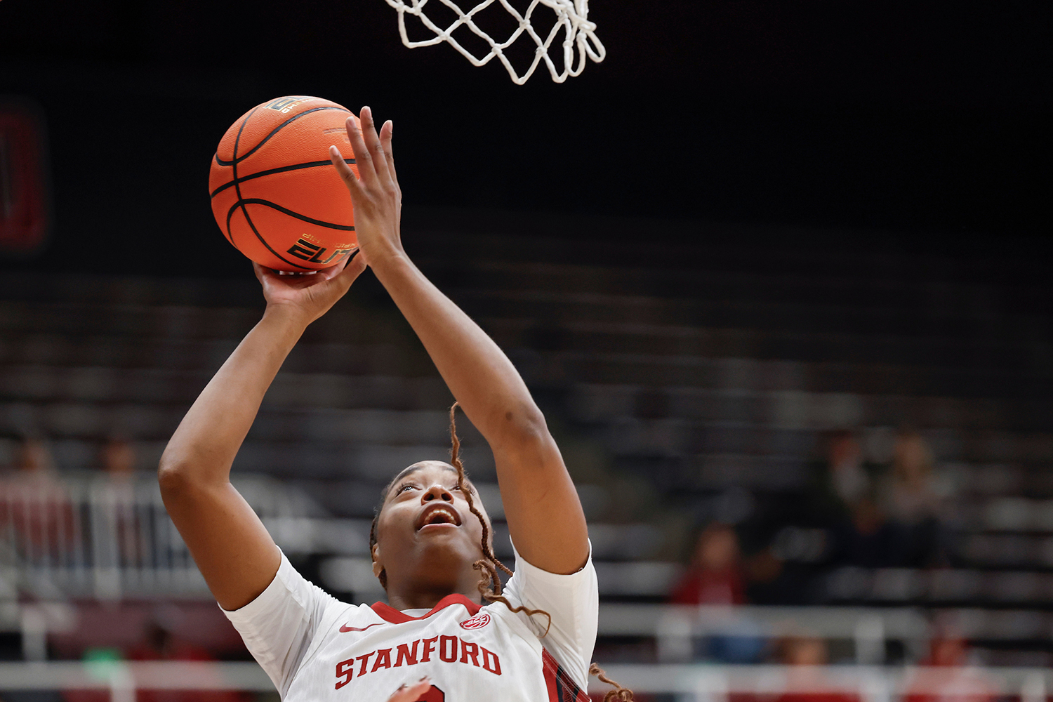 Image of a Cardinal men's basketball player shooting the ball at the hoop.