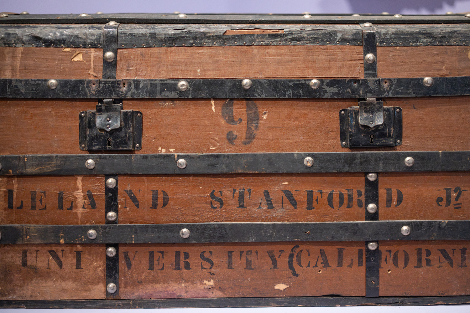 A vintage wooden trunk is marked with 
