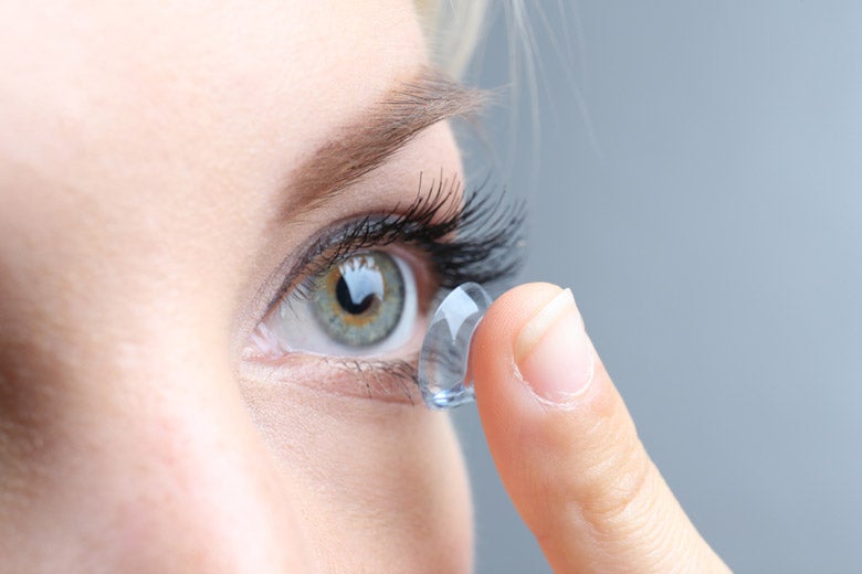 Closeup of woman putting contact lens in her eye
