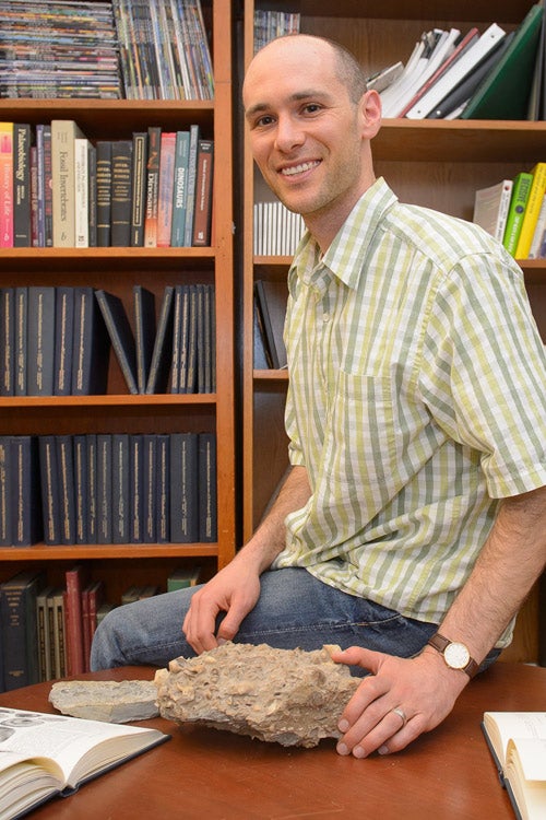 Jonathan Payne with rock infused with marine fossils / John Todd
