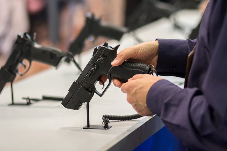 hands holding a gun at display desk