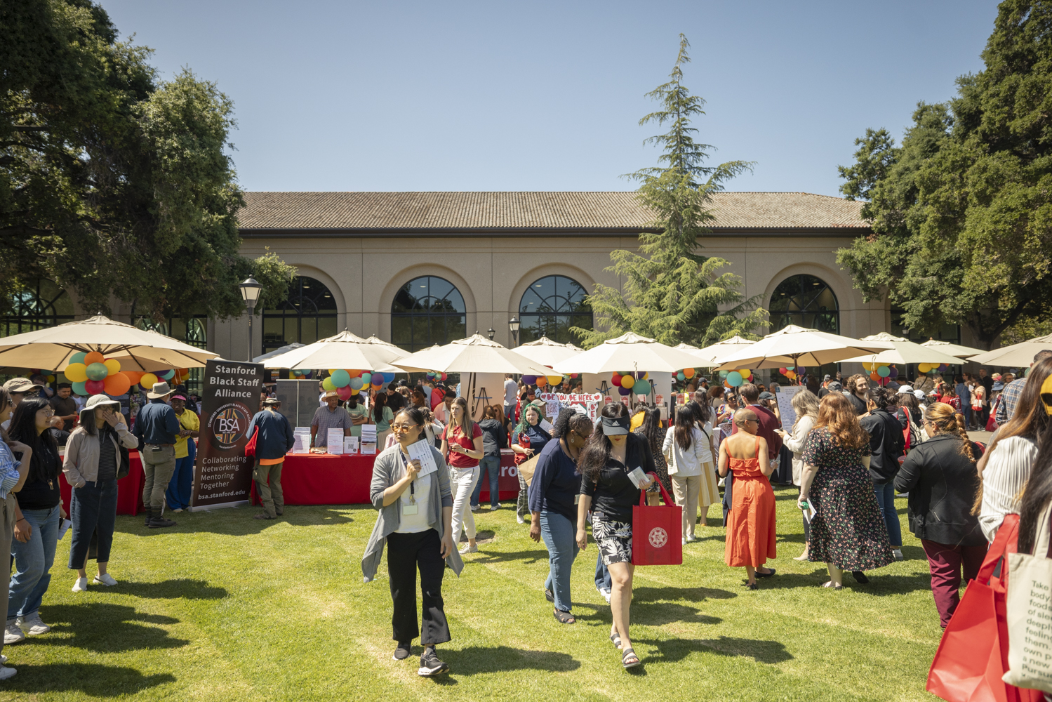 People walk toward booths on the lawn