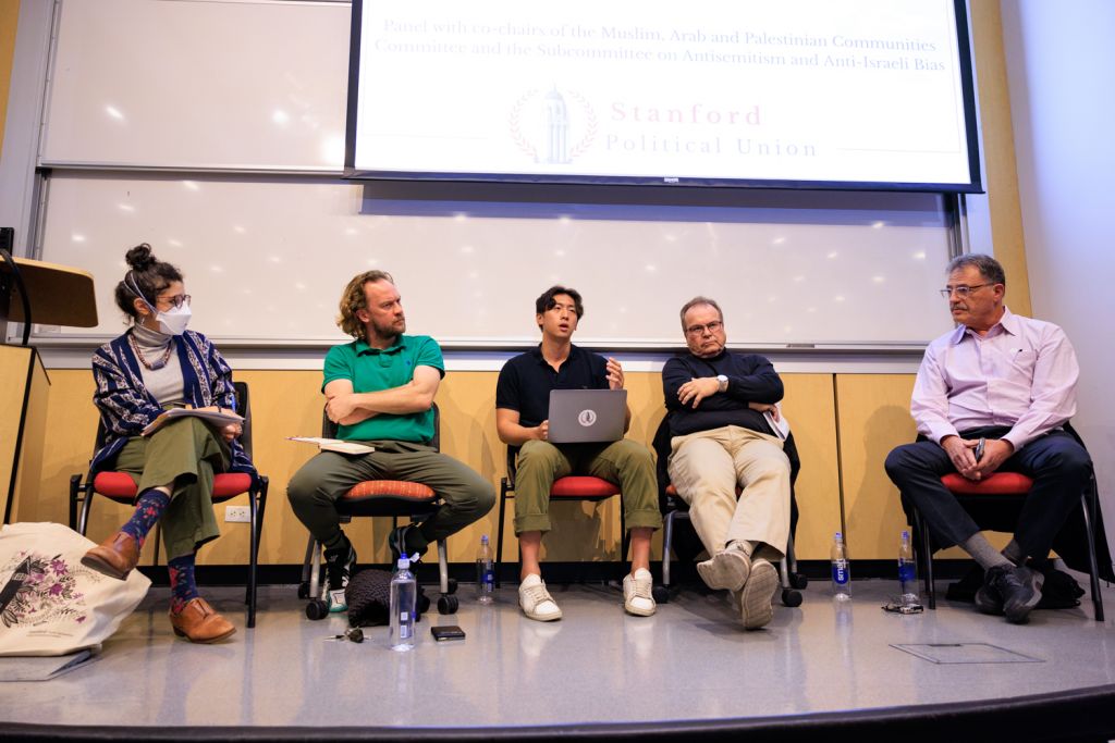 Image of panelists Natalie Jabbar, Alexander Key, YuQing Jiang, Jefferey Koseff, and Larry Diamond sitting on stage and speaking at an event hosted by the Stanford Political Union.