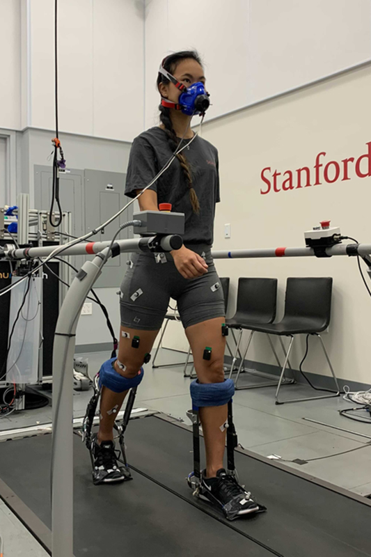 Image of Graduate student Guan Rong Tan walking on a treadmill while wearing the ankle exoskeleton.