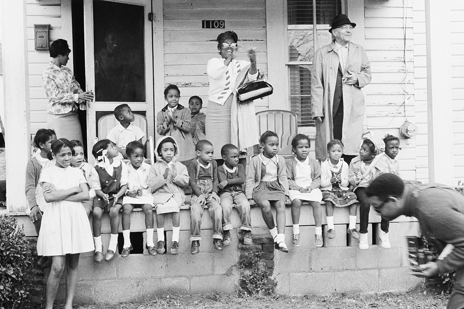 Onlookers, including a large group of children, watch the march.