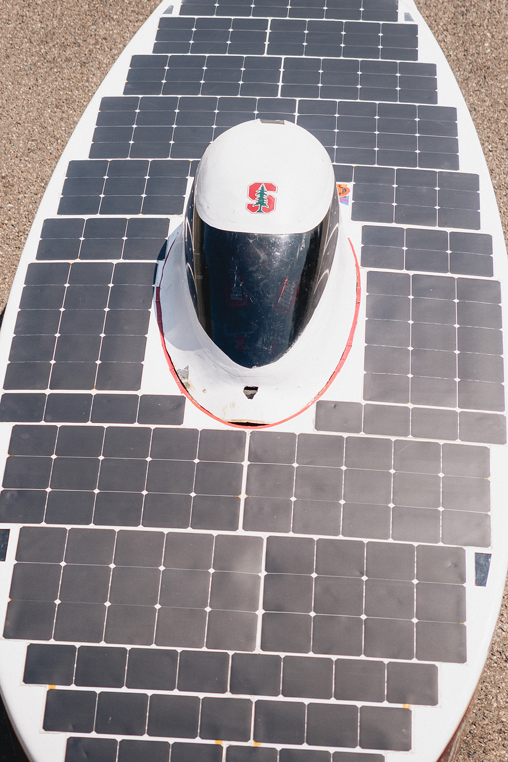 Overhead close-up of Stanford's solar car, showing the driver's bubble canopy ringed by rows of solar panels.