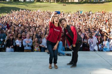 Seniors Cecilia Lang-Ree and Charlie Yang take a selfie with the entire class in the background.
