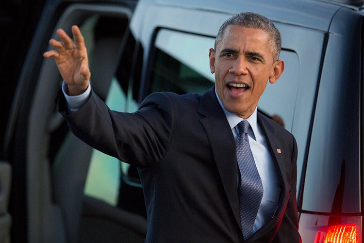 President Barack Obama waving as he leaves Air Force One