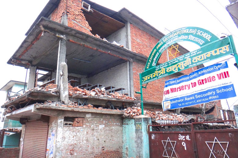 Nepali school with one of the floors visibly pancaked, other floors missing wall following April 25, 2015, earthquake