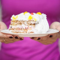 Piece of cake on a plate served women's hands