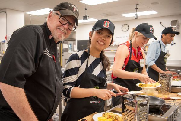 Chef and student in kitchen.