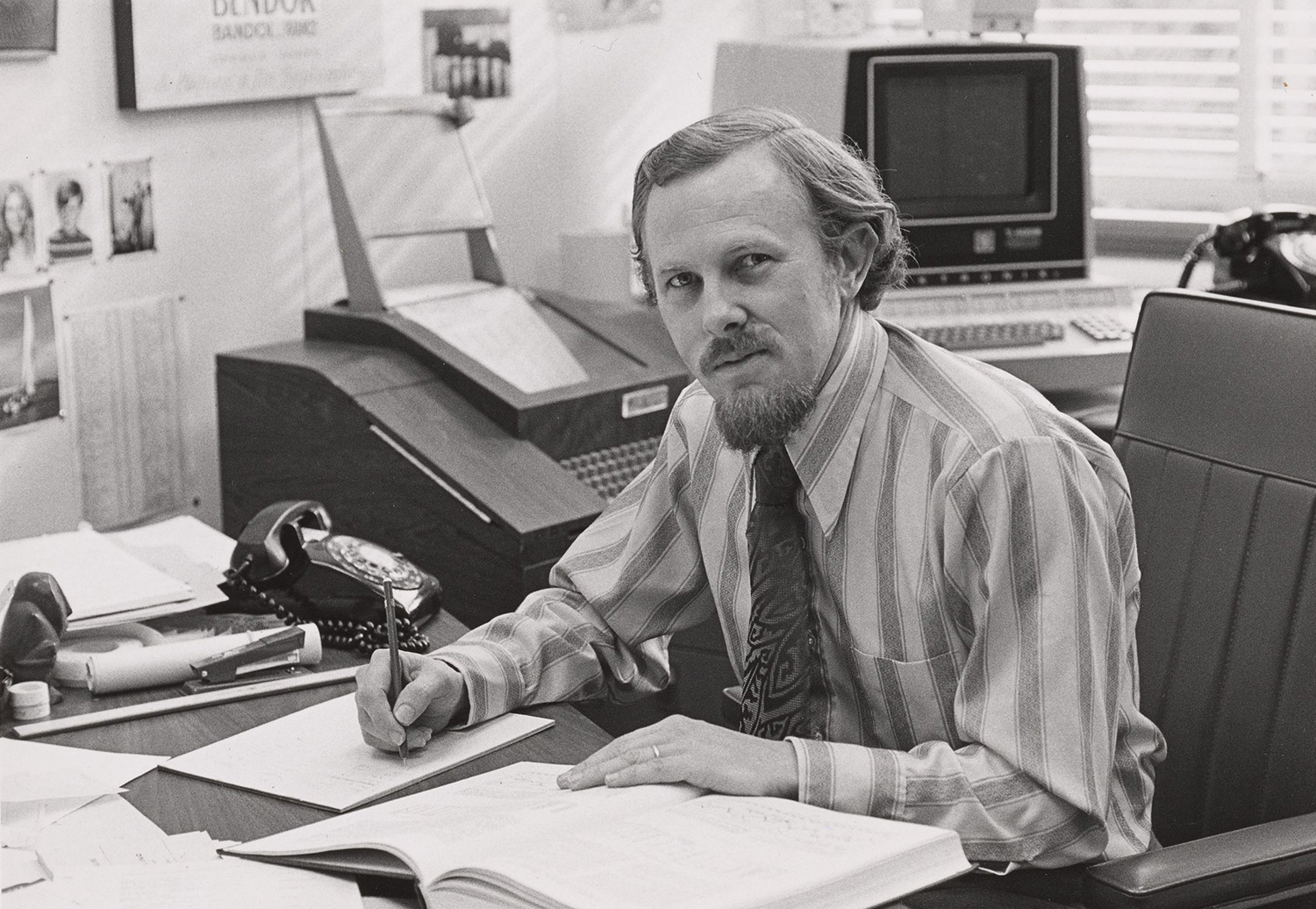 A black and white photo of William Sharpe sitting in his office.