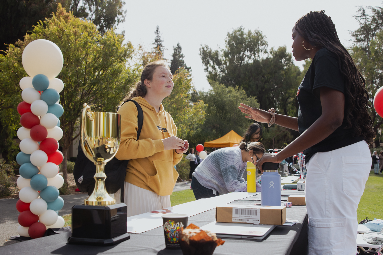 Two students converse across a table