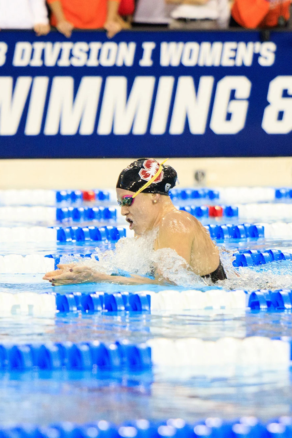 Ella Eastin competes in a race, splashing water as she propels herself forward.