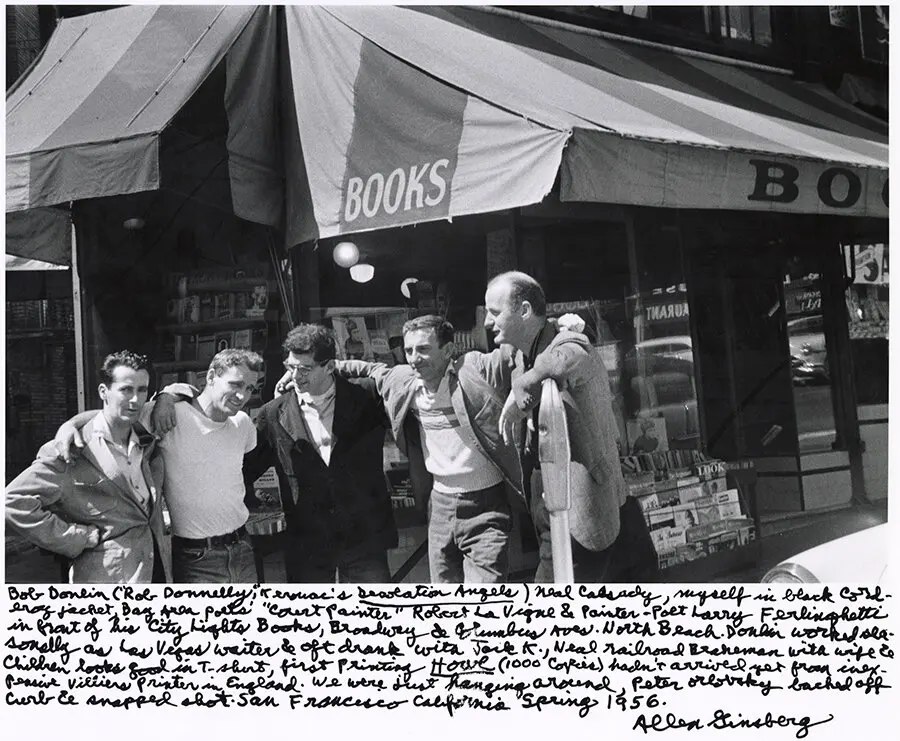 Bob Donlin, Neal Cassady, Ginsberg, Robert LaVigne, and Lawrence Ferlinghetti, stand outside a bookstore with a striped awning.