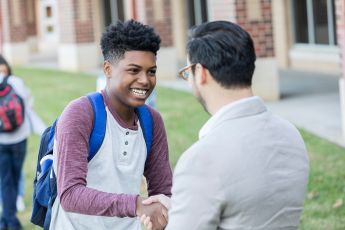 Teacher and student shake hands