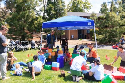 Families playing with giant Lego-style blocks.