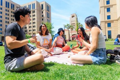 Students seated in a circle on the lawn.