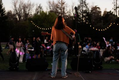 Student playing a guitar on stage.