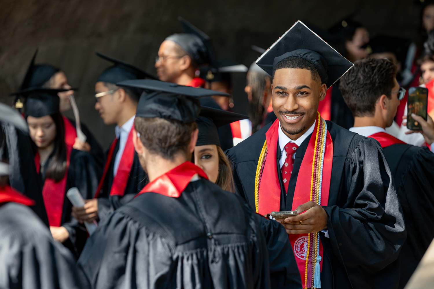 Smiling grad looks up from phone