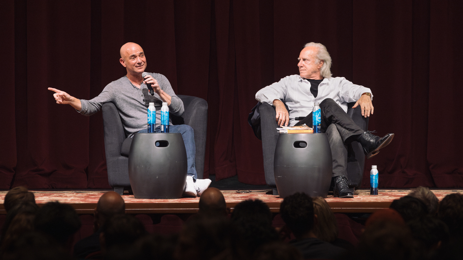 Image of Andre Agassi and Robert Harrison sitting on stage during a discussion at Stanford. 