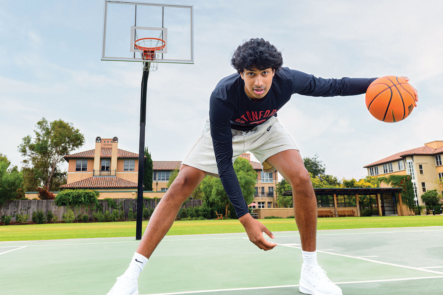 Open video Image of Ryan Agarwal on an outdoor basketball court and posing with a ball and looking at the camera. in a modal